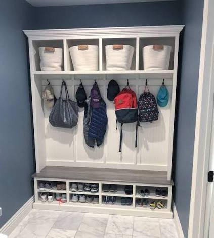 Built in mudroom bench with open shoe cubbies and boot trays