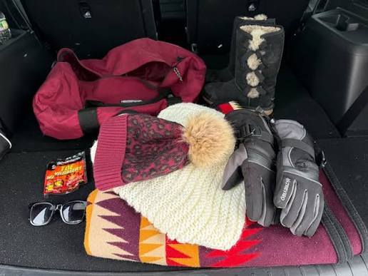 Emergency roadside kit laid out cleanly in a car trunk for winter survival